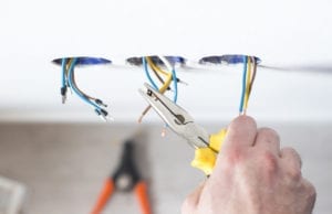 A Mister Sparky technician finishes a home electrical system repair in Houston.