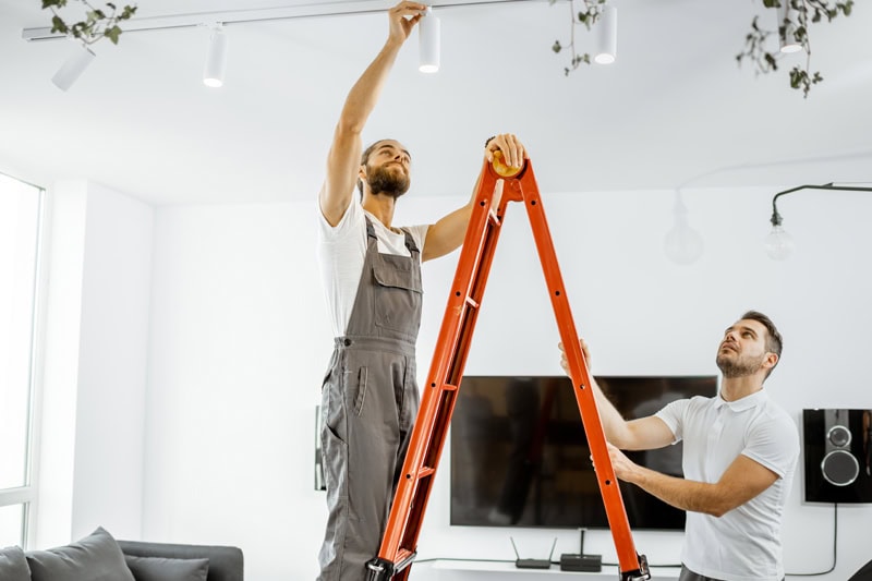 Does Your Home Need an Electrical Panel Upgrade? An electrician looking at a light fixture.
